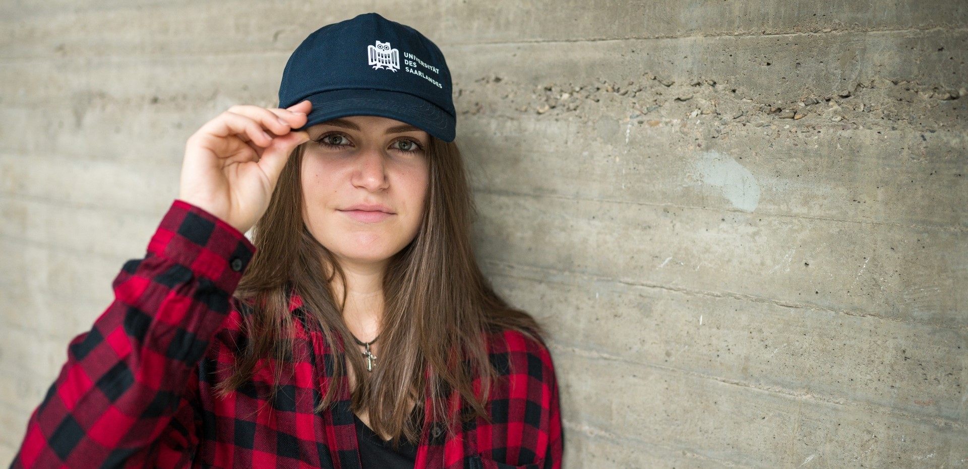 Studentin mit einer Basecap der Universität des Saarlandes