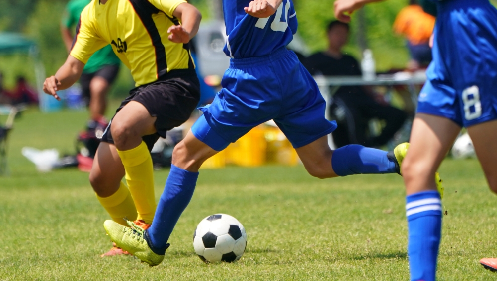 Beine von Fußballern mit Ball bei einem Fußballspiel