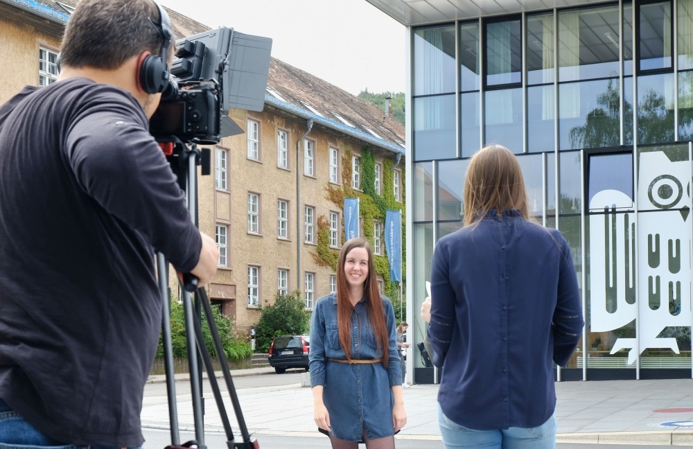 Dreharbeiten für ein Video: Kameramann filmt eine Frau vor dem Campus Centerdem Campus Saarbrücken