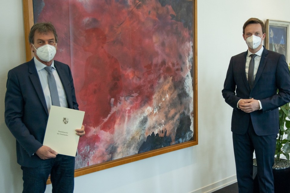 Manfred J. Schmitt (zeigt seine Ernennungsurkunde) und Tobias Hans, beide mit Corona-Schutzmasken