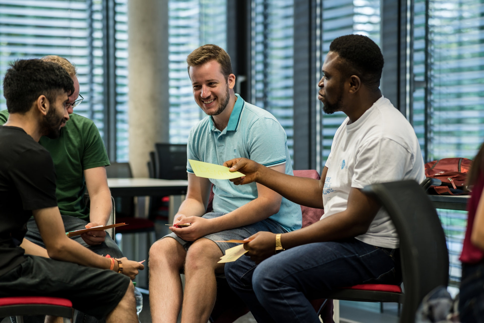 Studierende sitzen in der Gruppe im Seminar und diskutieren